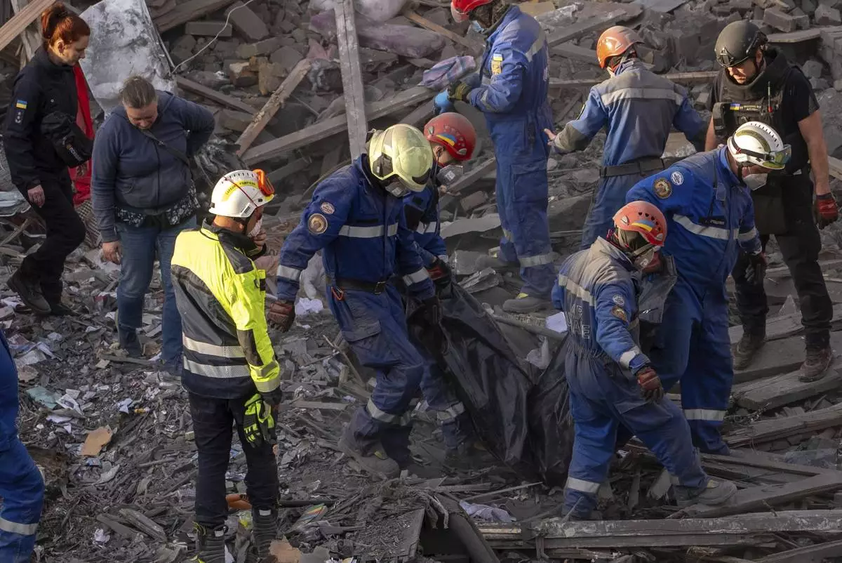 Rescue workers carry the body of a victim found under the rubble after a Russian strike in a residential neighborhood in Kyiv, Ukraine, Thursday, April 24, 2025. (AP Photo/Alex Babenko)