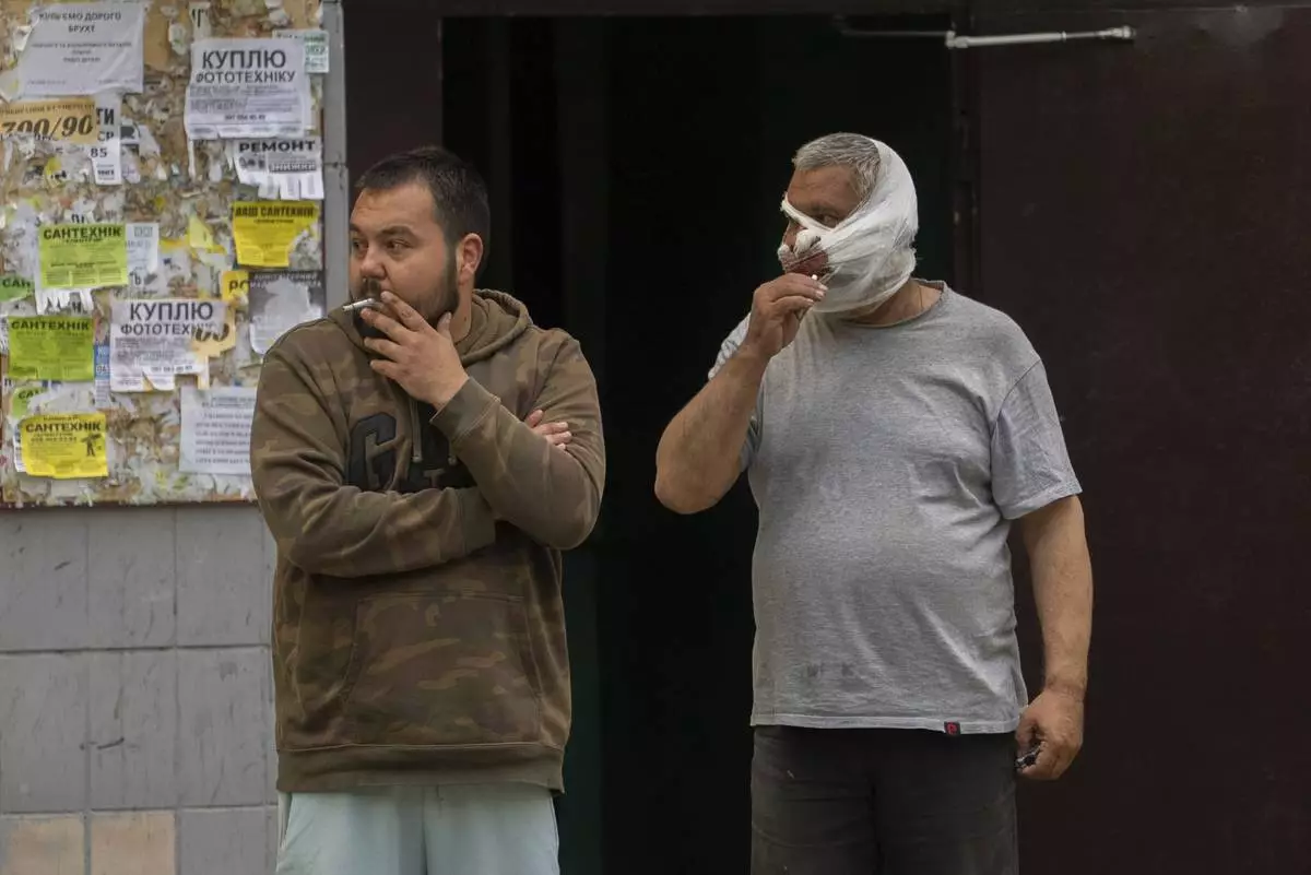Injured victims stand and smoke after a Russian airstrike in a residential neighborhood in Kyiv, Ukraine, Thursday, April 24, 2025. (AP Photo/Alex Babenko)