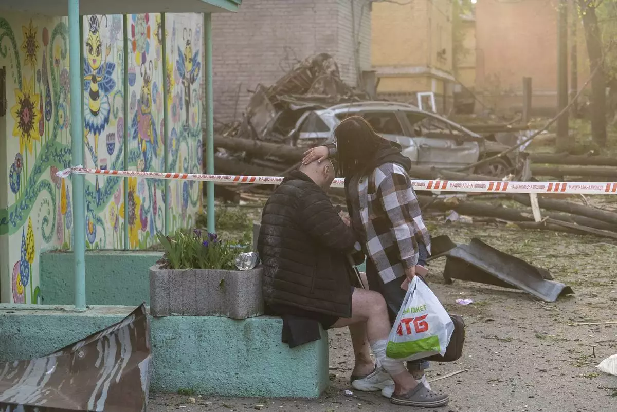 A woman helps an injured victim after a Russian strike in a residential neighborhood in Kyiv, Ukraine, Thursday, April 24, 2025. (AP Photo/Alex Babenko)