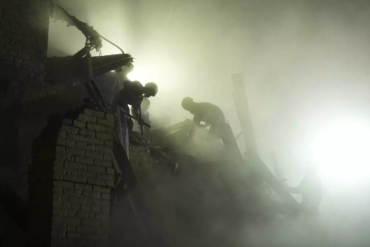 Ukrainian searchers clear the rubble after a Russian ballistic missile attack in Kyiv, Ukraine, early Thursday, April 24, 2025. (AP Photo/Efrem Lukatsky)