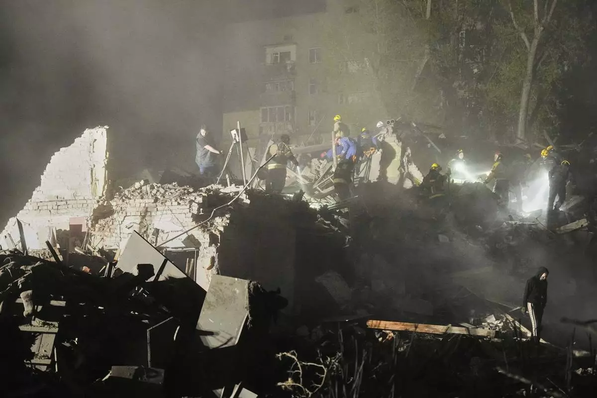 Ukrainian searchers clear the rubble after a Russian ballistic missile attack in Kyiv, Ukraine, early Thursday, April 24, 2025. (AP Photo/Efrem Lukatsky)