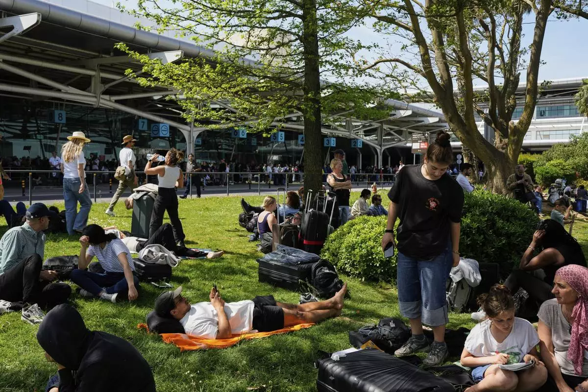 Passengers wait outside Lisbon Airport during a nationwide power outage in Lisbon, Monday, April 28, 2025. (AP Photo/Armando Franca)