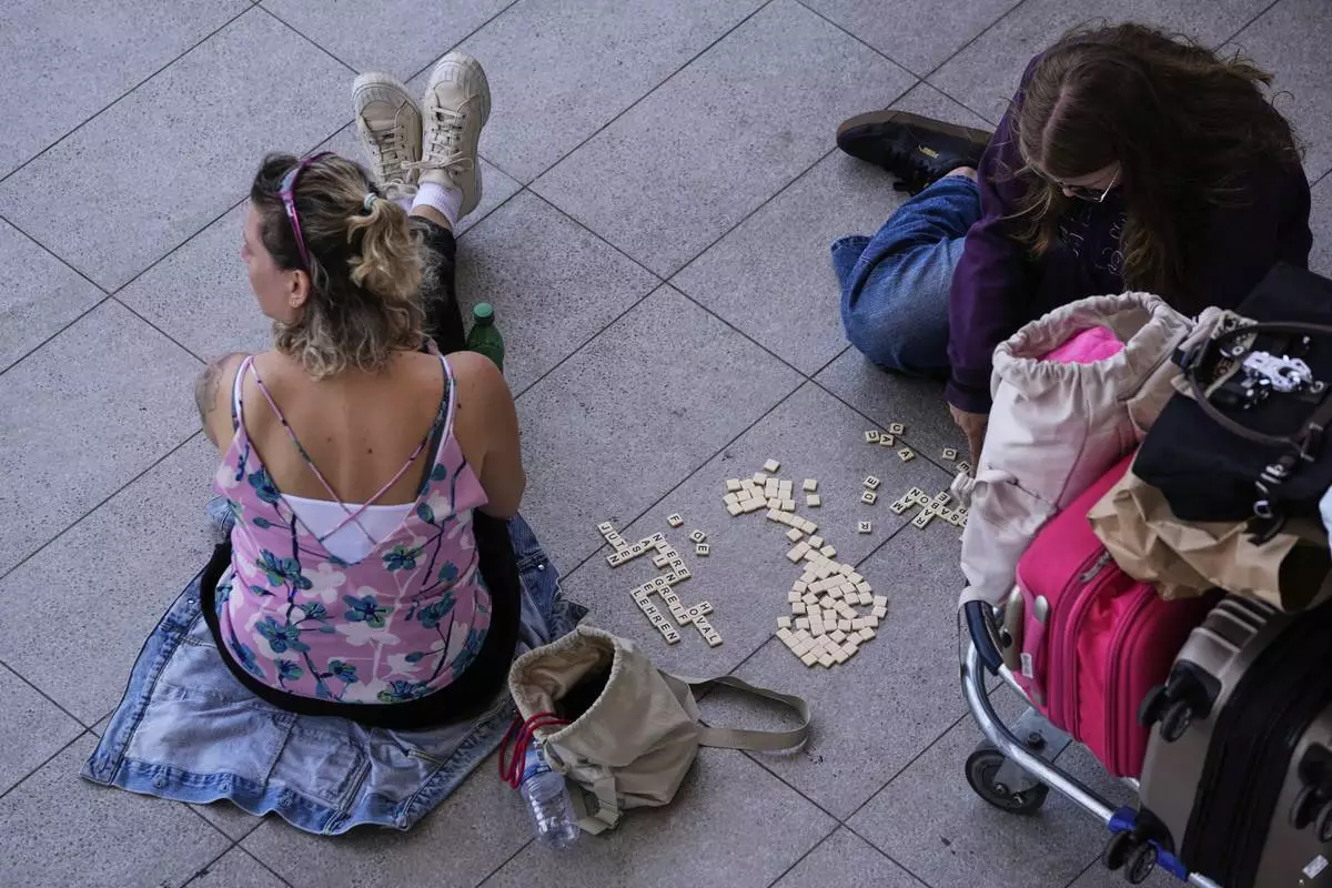 Passengers wait outside Lisbon Airport during a nationwide power outage in Lisbon, Monday, April 28, 2025. (AP Photo/Armando Franca)