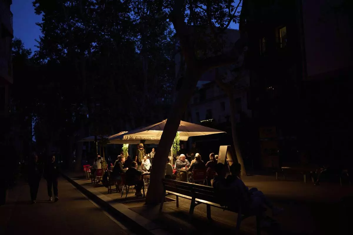Customers dine in a restaurant illuminated by a generator during a blackout in Barcelona, Spain, Monday, April 28, 2025. (AP Photo/Emilio Morenatti)