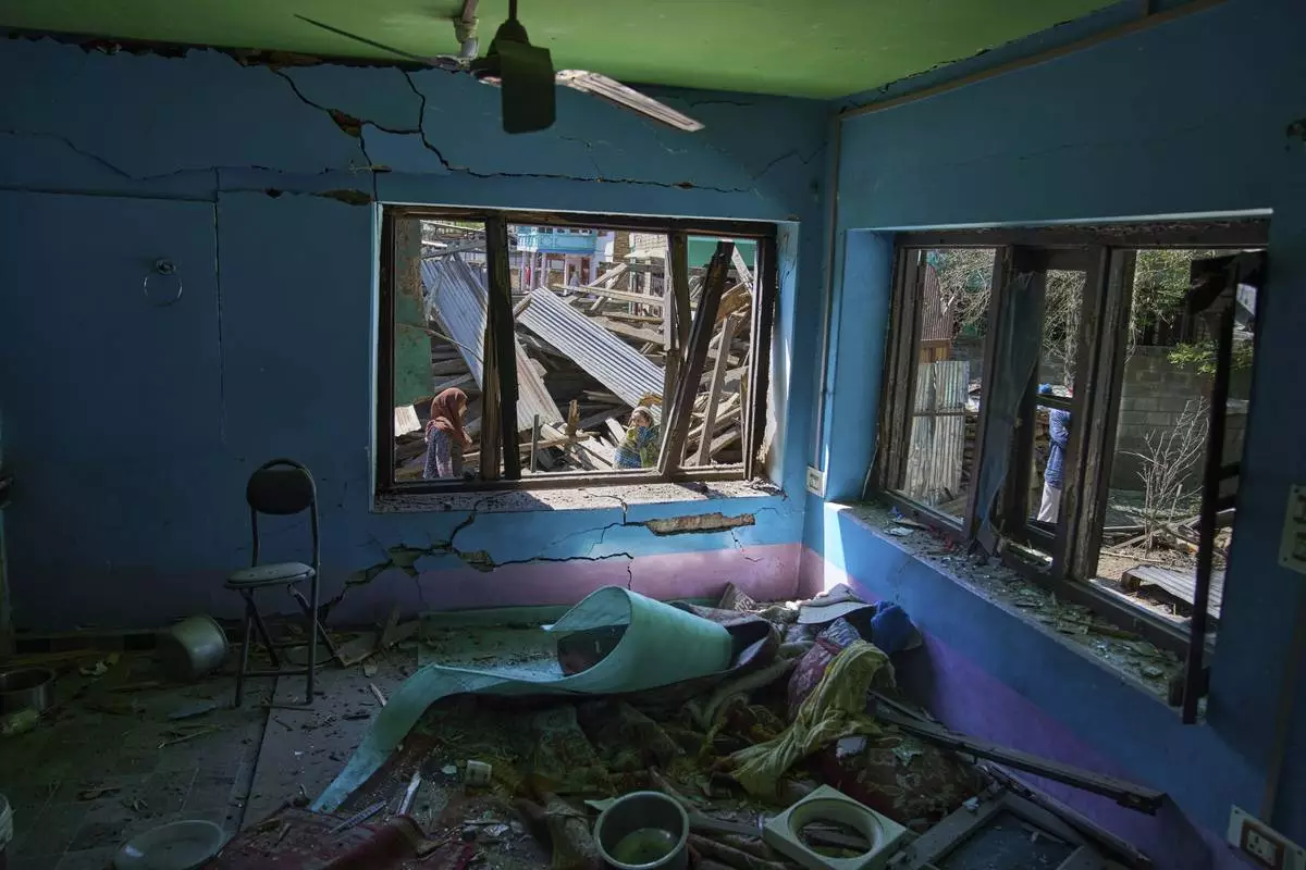 Kashmiri women inspect the blown-up family home of Asif Shiekh, a militant who officials say is involved in the deadly attack on tourists in Pahalgam, at Monghama village in Tral, south of Srinagar, Indian controlled Kashmir, Friday, April 25, 2025. (AP Photo/Dar Yasin)