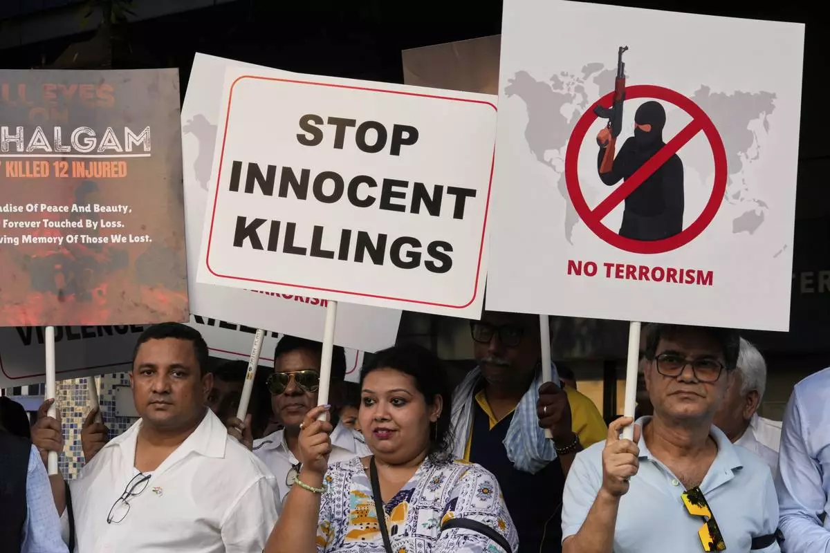 Members of airlines and tourism facility providers walk with posters during a protest against the killing of tourists by militants near Pahalgam in Indian controlled Kashmir, in Kolkata, India, Thursday, April 24, 2025. (AP Photo/Bikas Das)