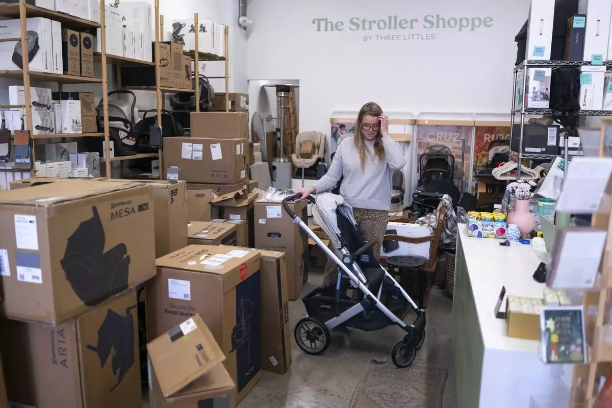 Elizabeth Mahon, owner of baby store Three Littles, unpacks strollers and other inventory ordered by customers ahead of tariff-driven price increases at her Union Market location in Washington, on Wednesday, April 16, 2025. (AP Photo/Nathan Howard)