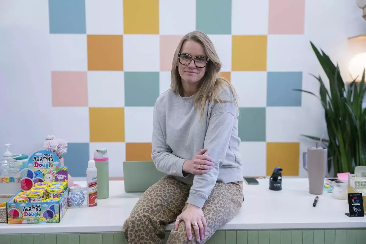 Elizabeth Mahon, owner of the baby store Three Littles, poses for a photo at her Union Market location in Washington, on Wednesday, April 16, 2025. (AP Photo/Nathan Howard)