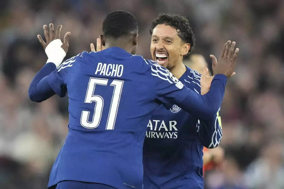 PSG's Marquinhos celebrates with PSG's Willian Pacho at the end of the Champions League quarterfinal second leg soccer match between Aston Villa and Paris Saint-Germain at the Villa Park stadium, in Birmingham, England, Tuesday, April 15, 2025. (AP Photo/Frank Augstein)