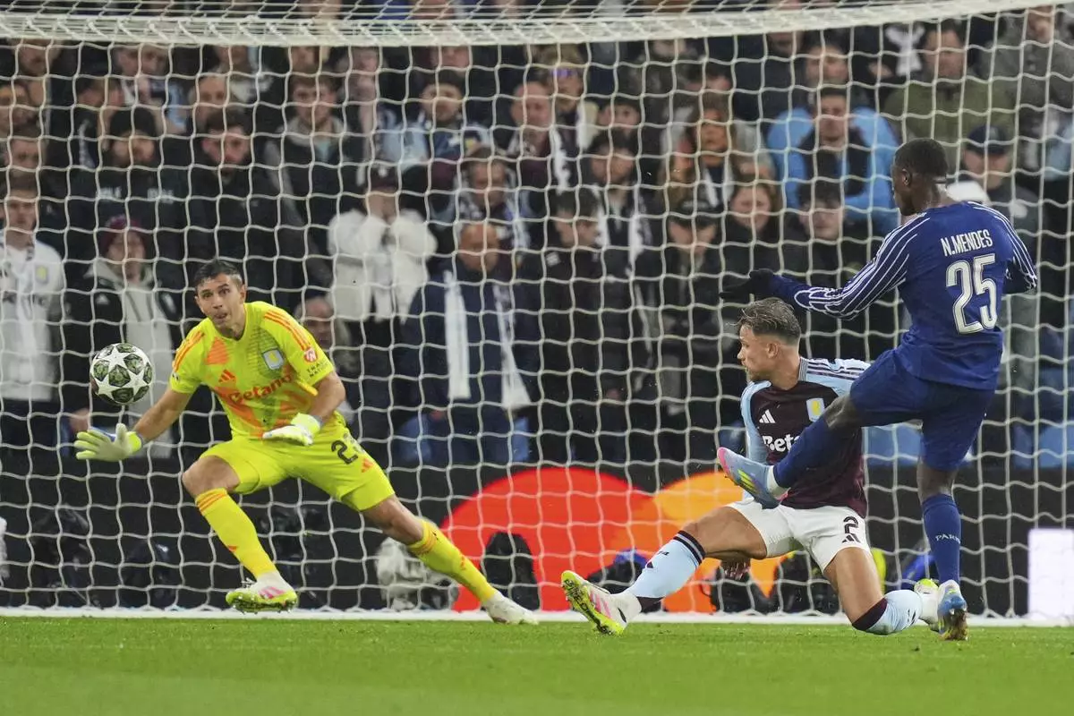 PSG's Nuno Mendes, right, scores his side's second goal during the Champions League quarterfinal second leg soccer match between Aston Villa and Paris Saint-Germain at Villa Park stadium, Birmingham, England, Tuesday, April 15, 2025. (AP Photo/Kirsty Wigglesworth)