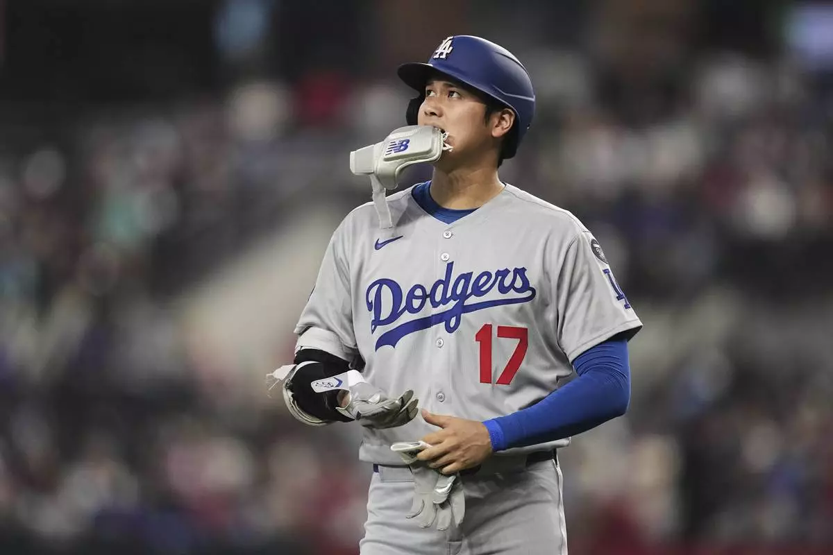 Los Angeles Dodgers' Shohei Ohtani walks to the dugout after grounding out to first in the fifth inning of a baseball game against the Texas Rangers in Arlington, Texas, Sunday, April 20, 2025. (AP Photo/Tony Gutierrez)