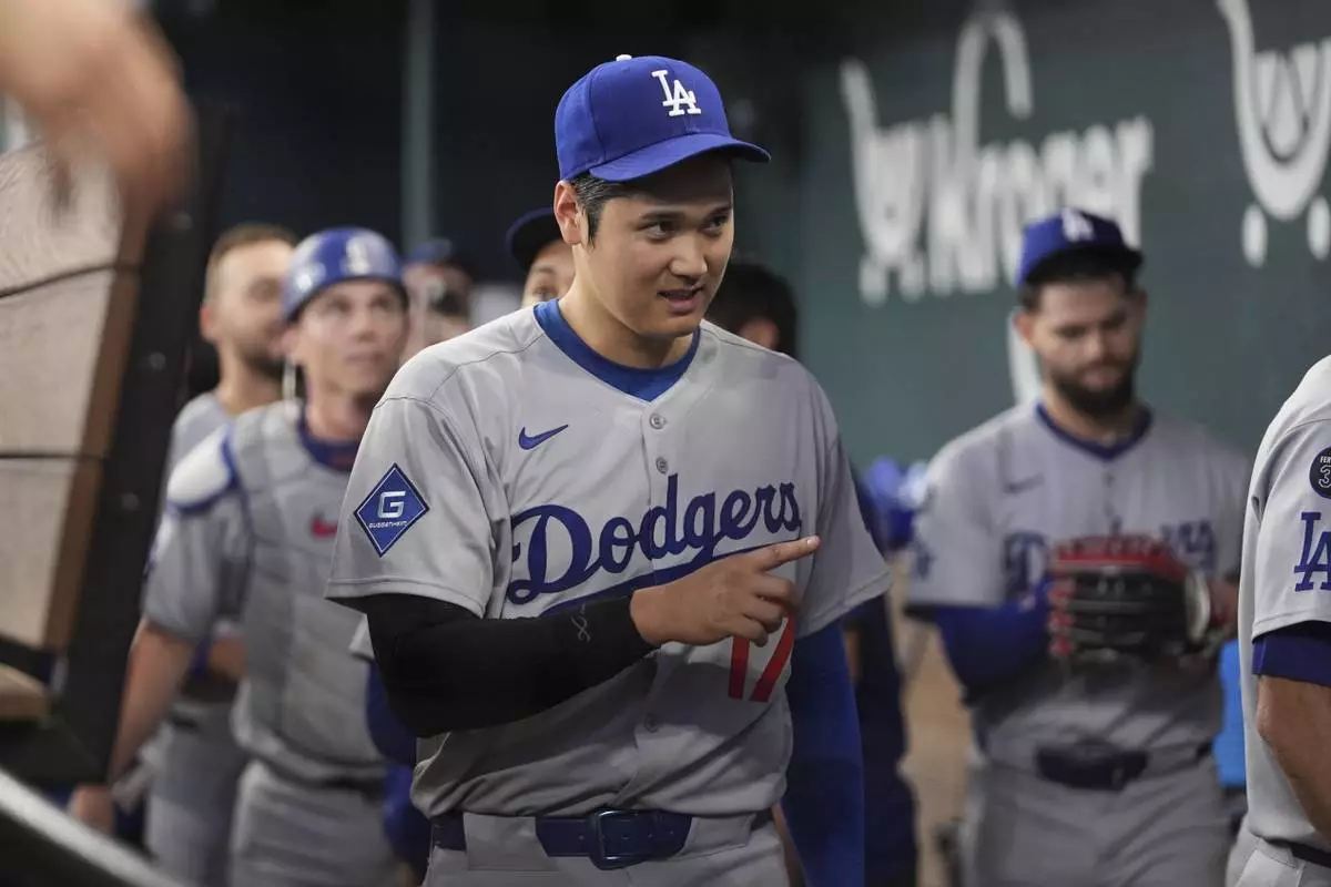 Los Angeles Dodgers' Shohei Ohtani celebrates the team's win following a baseball game against the Texas Rangers in Arlington, Texas, Sunday, April 20, 2025. (AP Photo/Tony Gutierrez)