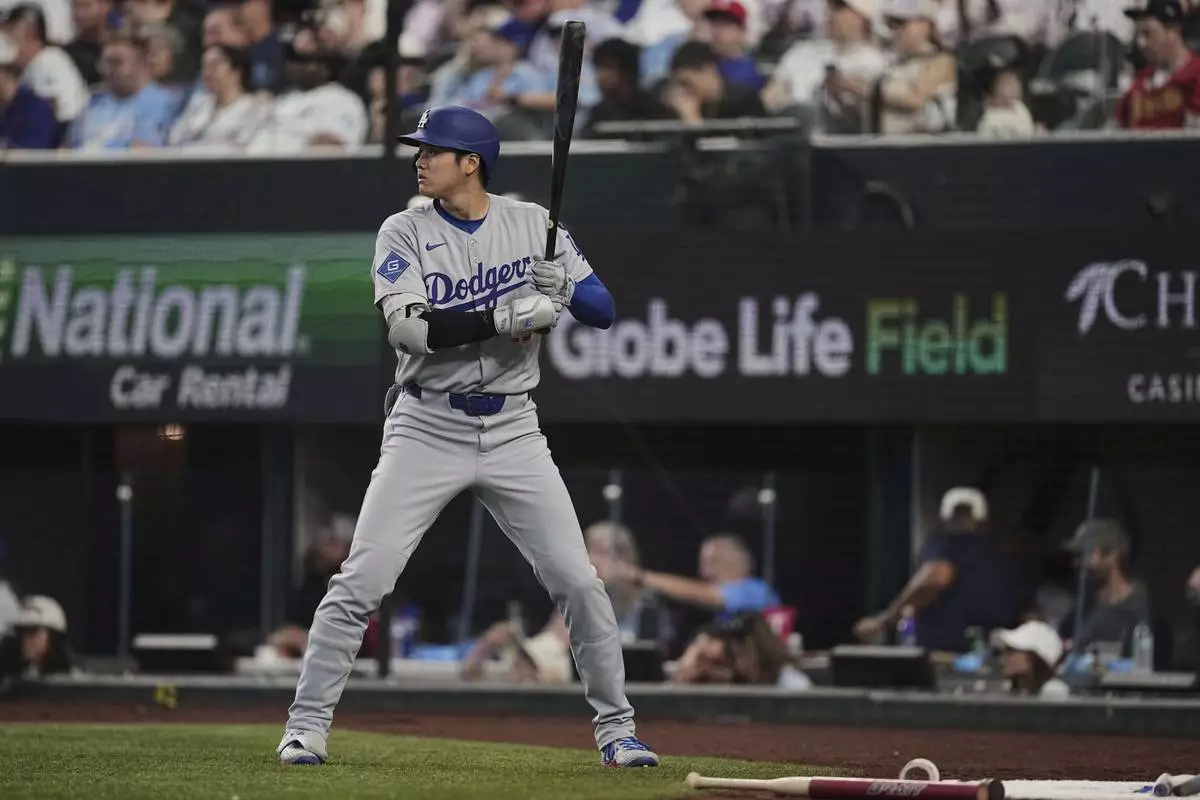 Los Angeles Dodgers' Shohei Ohtani stands on deck in the eighth inning of a baseball game against the Texas Rangers in Arlington, Texas, Sunday, April 20, 2025. (AP Photo/Tony Gutierrez)