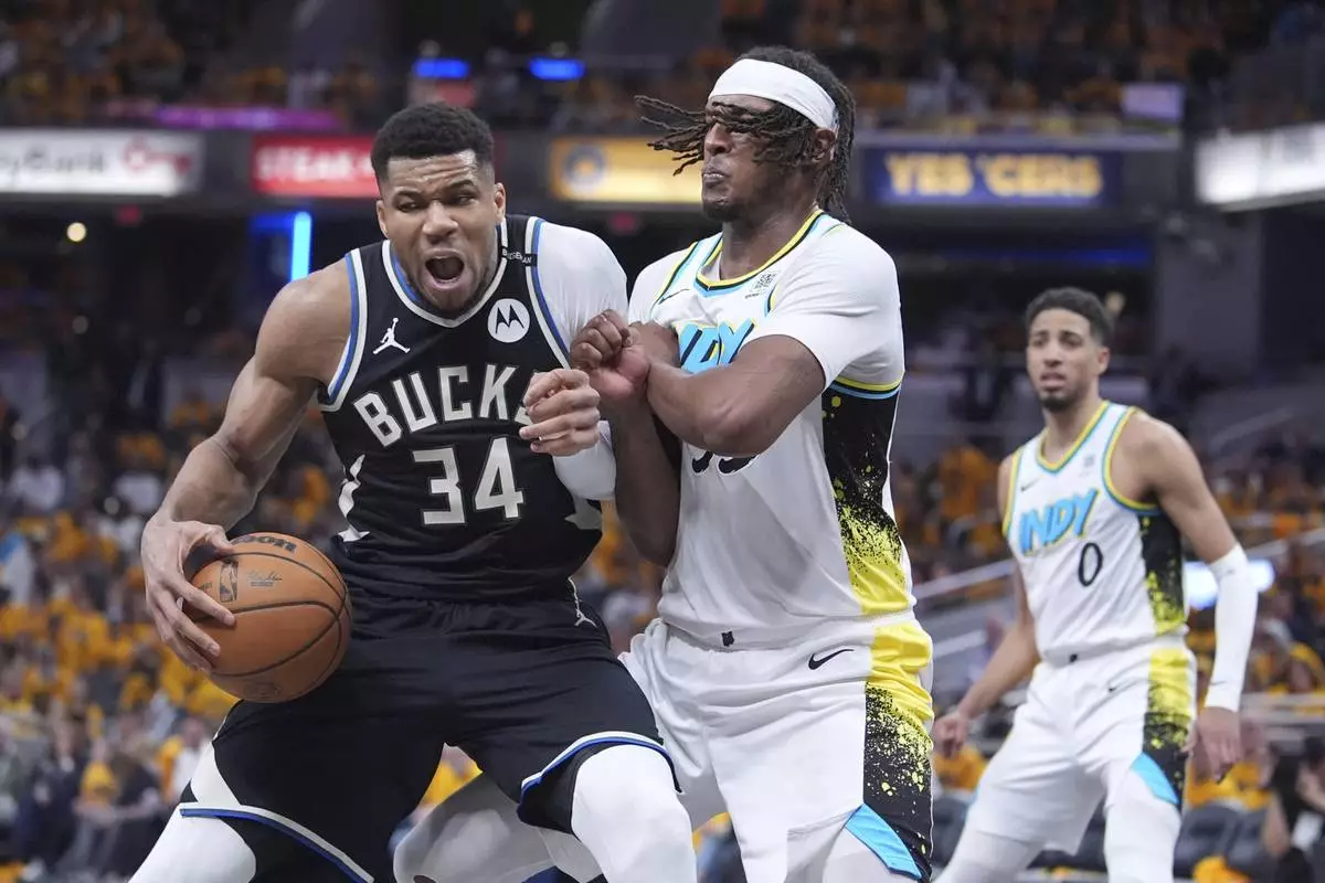 Milwaukee Bucks' Giannis Antetokounmpo (34) battles with Indiana Pacers' Myles Turner, right, during the second half of a first-round NBA basketball playoff game, Saturday, April 19, 2025, in Indianapolis. (AP Photo/Michael Conroy)