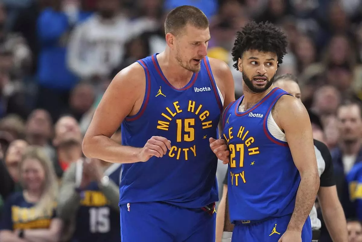 Denver Nuggets center Nikola Jokic, left, confers with guard Jamal Murray, right, in the second half of Game 1 of an NBA first-round playoff series against the Los Angeles Clippers, Saturday, April 19, 2025, in Denver. (AP Photo/David Zalubowski)