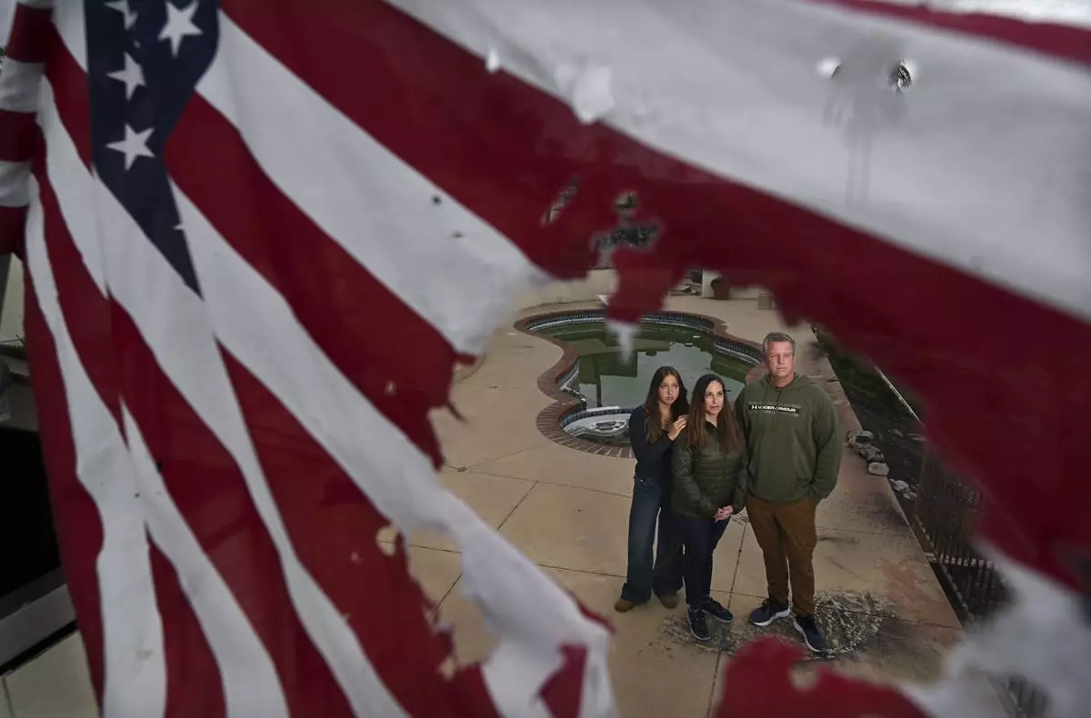 Keith and Rachel McNett stand with their daughter Teagan, left, where their house burned from the Mountain Fire Wednesday, April 16, 2025, in Camarillo, Calif. (AP Photo/Wally Skalij)