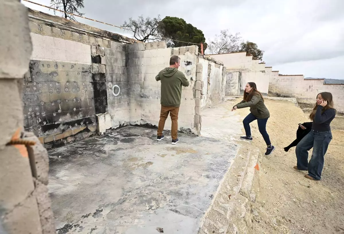 Keith and Rachel McNett along with daughter Teagan, right, visit there house that burned in the Mountain Fire Wednesday, April 16, 2025, in Camarillo, Calif. (AP Photo/Wally Skalij)