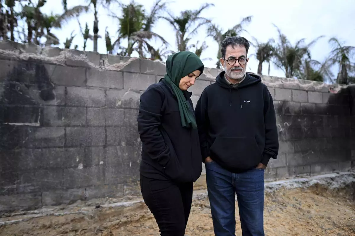Hatim Naim and his wife Samah stand in a shell of what was their house after it burned in the Mountain Fire Wednesday, April 16, 2025, in Somis, Calif. (AP Photo/Wally Skalij)