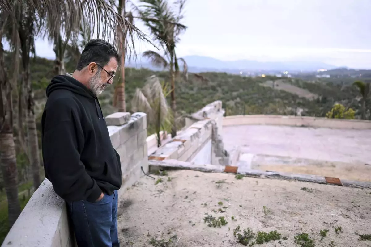 Hatim Naim stands in the ruins of his property which burned in the Mountain Fire Wednesday, April 16, 2025, in Somis, Calif. (AP Photo/Wally Skalij)