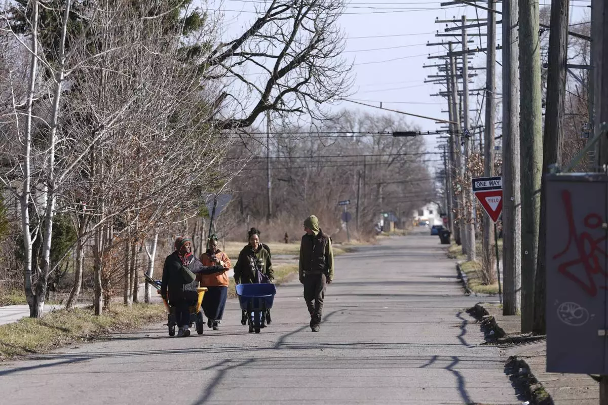 Robyn Redding, from left, Jozie Bullard, Gianna Holliday and Andrew "Birch" Kemp walk to a Arboretum Detroit parcel in Detroit, Friday, March 21, 2025. (AP Photo/Paul Sancya)