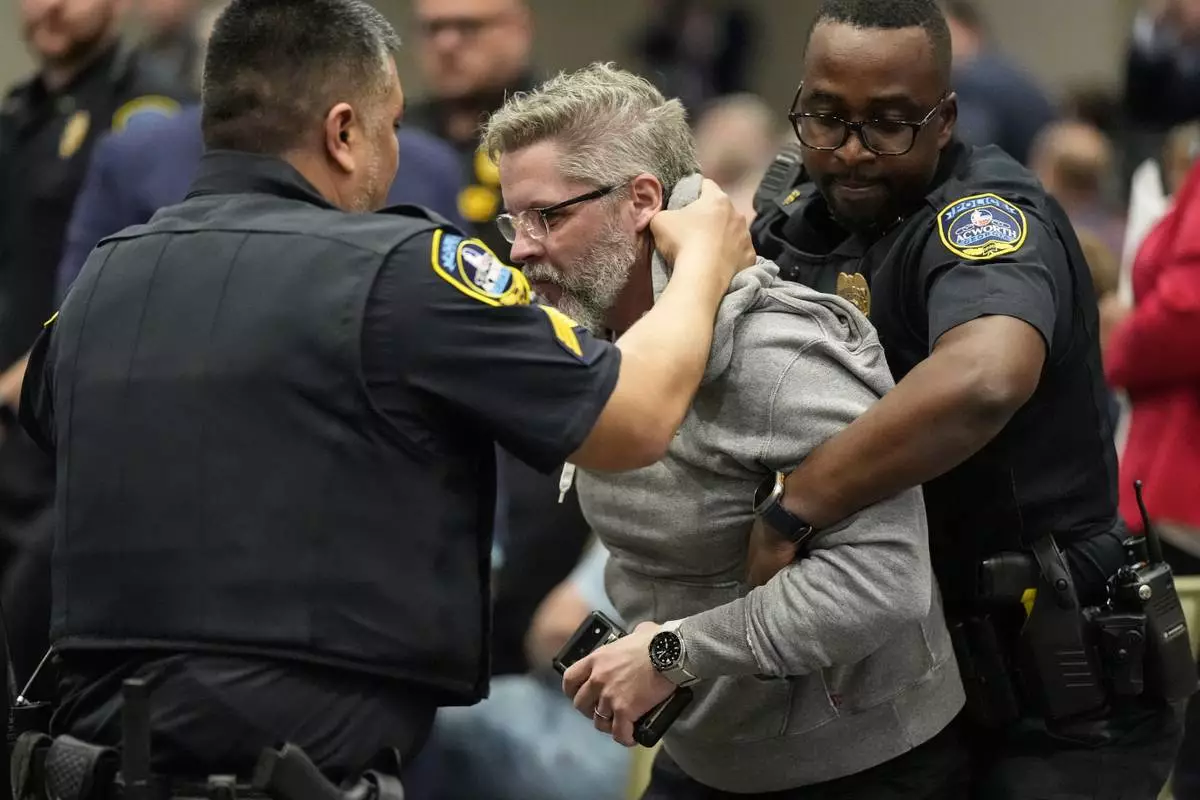 A protester is removed as Rep. Marjorie Taylor Greene, R-Ga., speaks during a town-hall style meeting, Tuesday, April 15, 2025, in Acworth, Ga. (AP Photo/Mike Stewart)