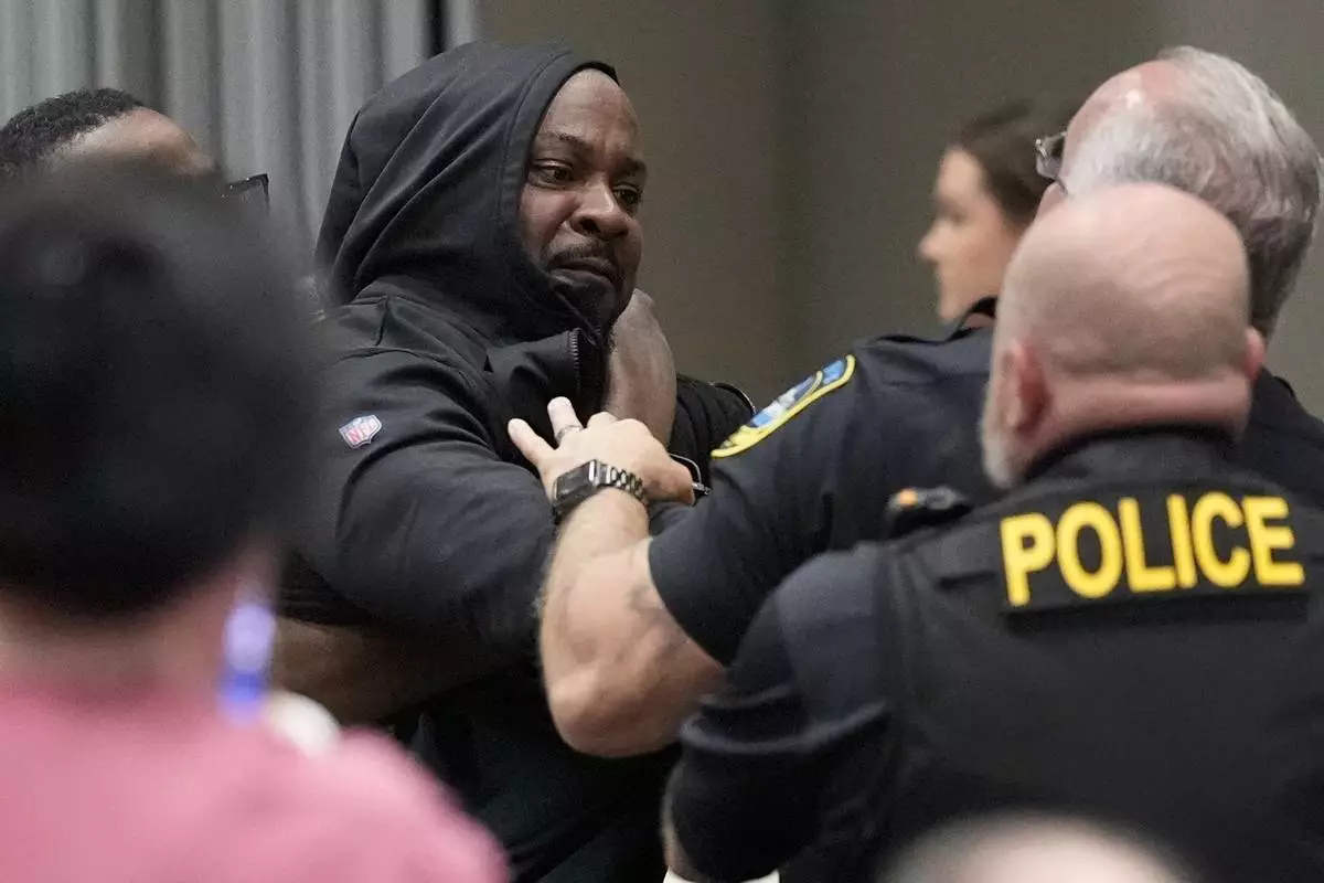 A protester is removed before a electronic non-leathal device was used as Rep. Marjorie Taylor Greene, R-Ga., speaks during a town-hall style meeting, Tuesday, April 15, 2025, in Acworth, Ga. (AP Photo/Mike Stewart)