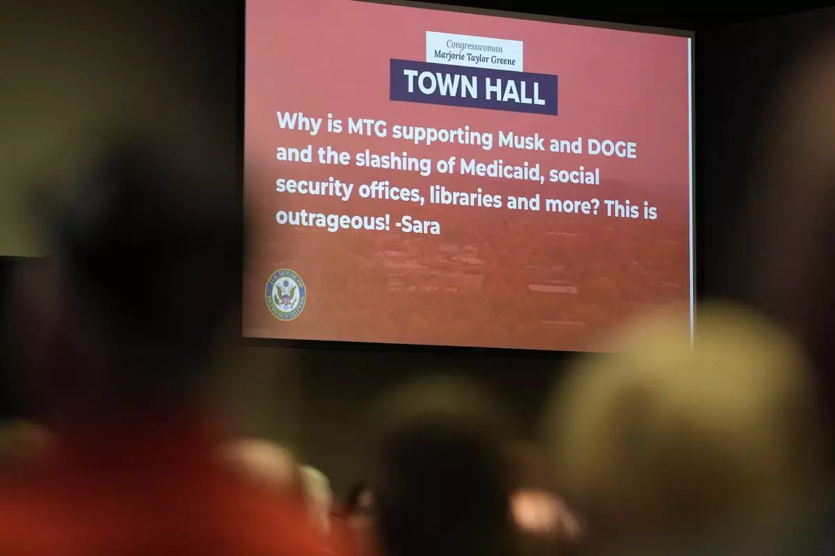 People listen to Rep. Marjorie Taylor Greene, R-Ga., as she speaks during a town-hall style meeting, Tuesday, April 15, 2025, in Acworth, Ga. (AP Photo/Mike Stewart)