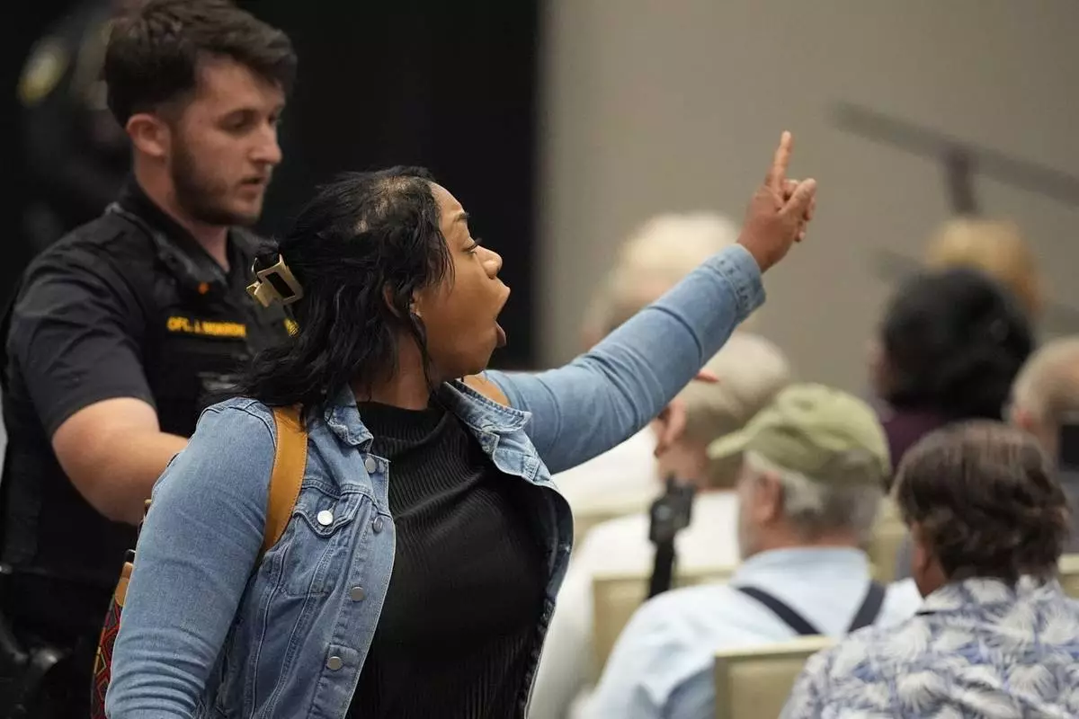 A protester is removed as Rep. Marjorie Taylor Greene, R-Ga., speaks during a town-hall style meeting, Tuesday, April 15, 2025, in Acworth, Ga. (AP Photo/Mike Stewart)