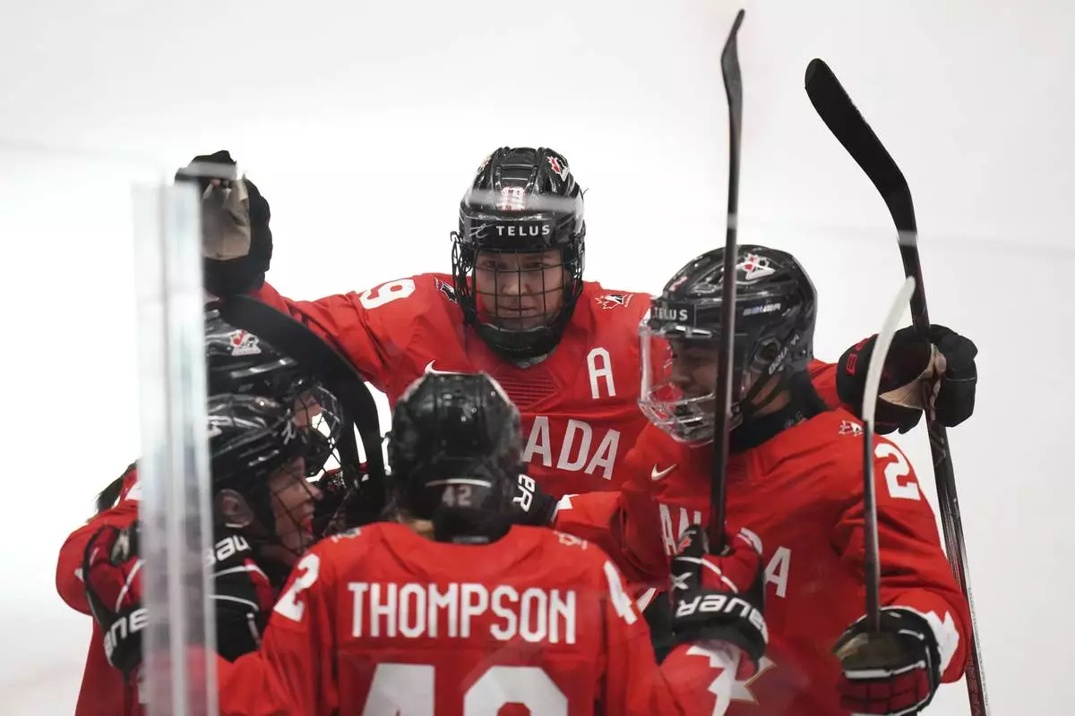 Claire Thompson of Canada, down, celebrates with teammates after scoring her sides first goal during the quarterfinal match between Canada and Japan at the Women's Ice Hockey Championships in Ceske Budejovice, Czech Republic, Thursday, April 17, 2025. (AP Photo/Petr David Josek)