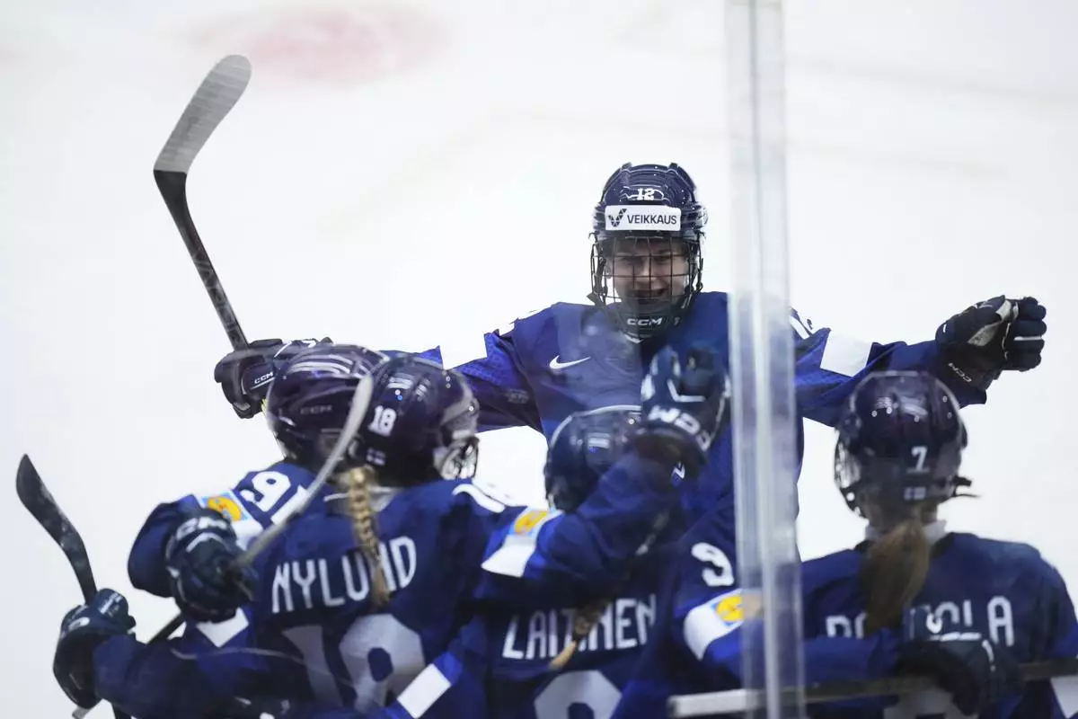 Finland's Jenniina Nylund, 2nd left, celebrates with teammates after scoring her sides first goal during the quarterfinal match between Finland and Sweden at the Women's Ice Hockey Championships in Ceske Budejovice, Czech Republic, Thursday, April 17, 2025. (AP Photo/Petr David Josek)