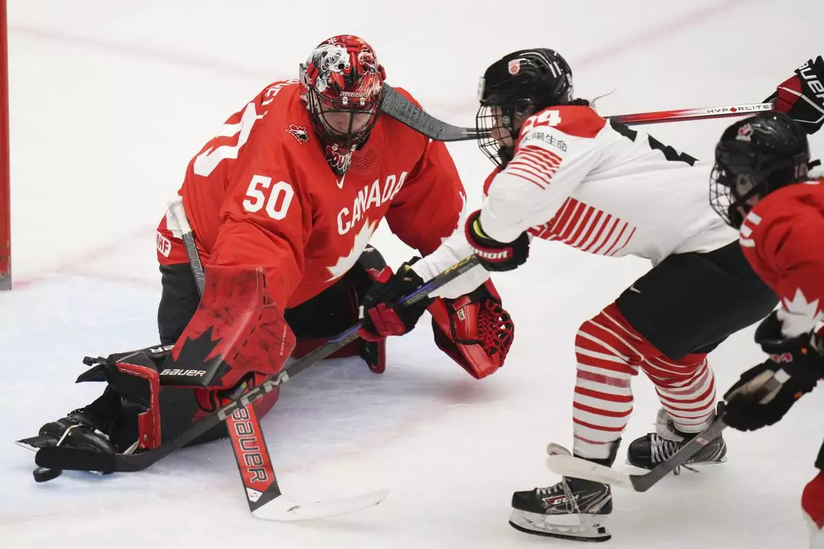 Japan's Mei Miura, right, scores her sides first goal past Kristen Campbell of Canada during the quarterfinal match between Canada and Japan at the Women's Ice Hockey Championships in Ceske Budejovice, Czech Republic, Thursday, April 17, 2025. (AP Photo/Petr David Josek)