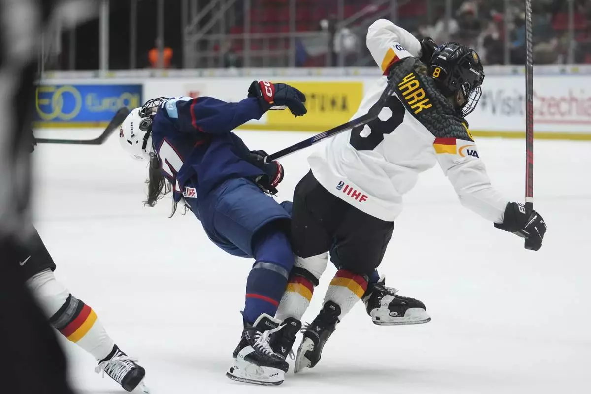 Germany's Ronja Hark, right, chatges United States' Abbey Murphy during the quarterfinal match between United States and Germany at the Women's Ice Hockey Championships in Ceske Budejovice, Czech Republic, Thursday, April 17, 2025. (AP Photo/Petr David Josek)