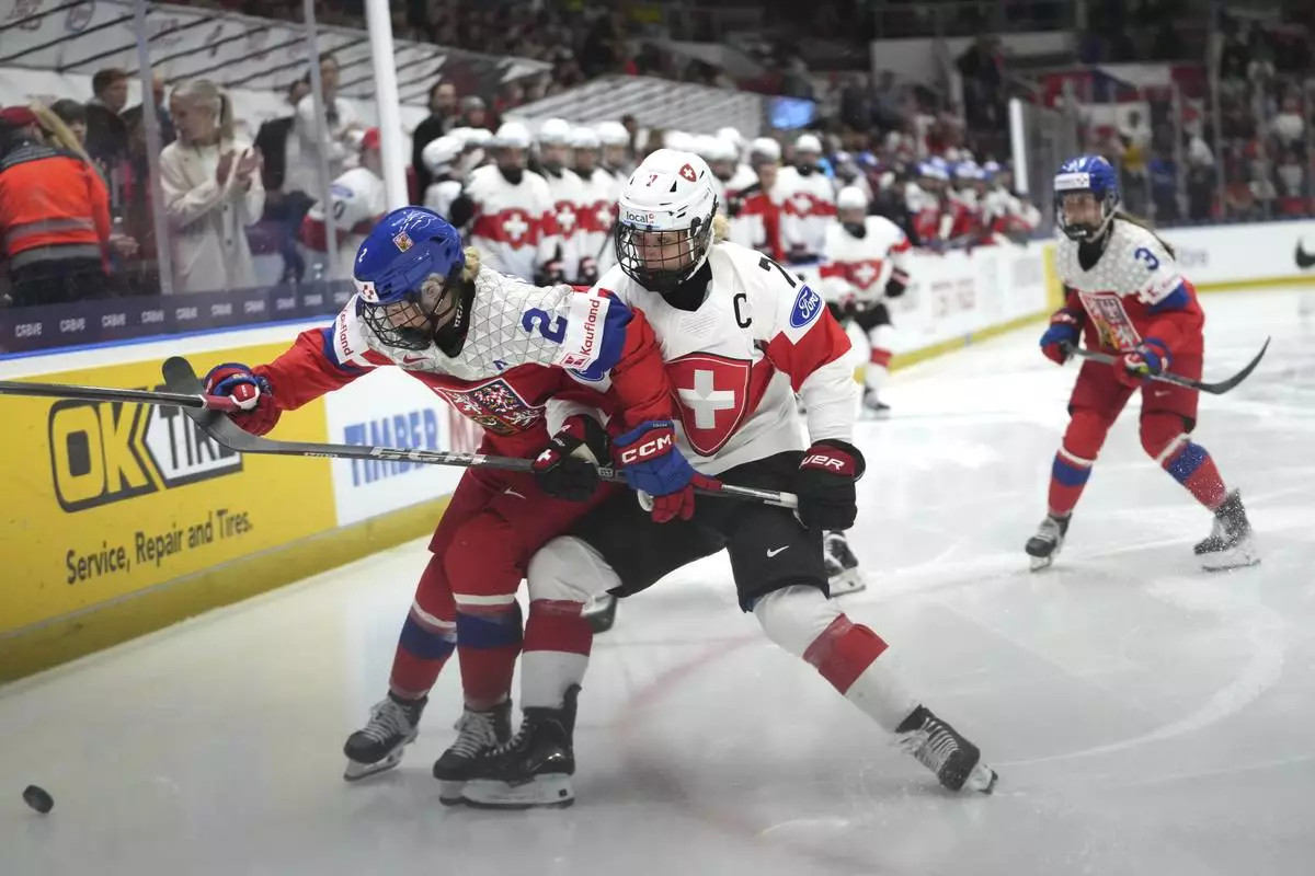 Lara Stalder of Switzerland, right, challenges Aneta Tejralova of Czech Republic during the quarterfinal match between Czech Republic and Switzerland at the Women's Ice Hockey Championships in Ceske Budejovice, Czech Republic, Thursday, April 17, 2025. (AP Photo/Petr David Josek)