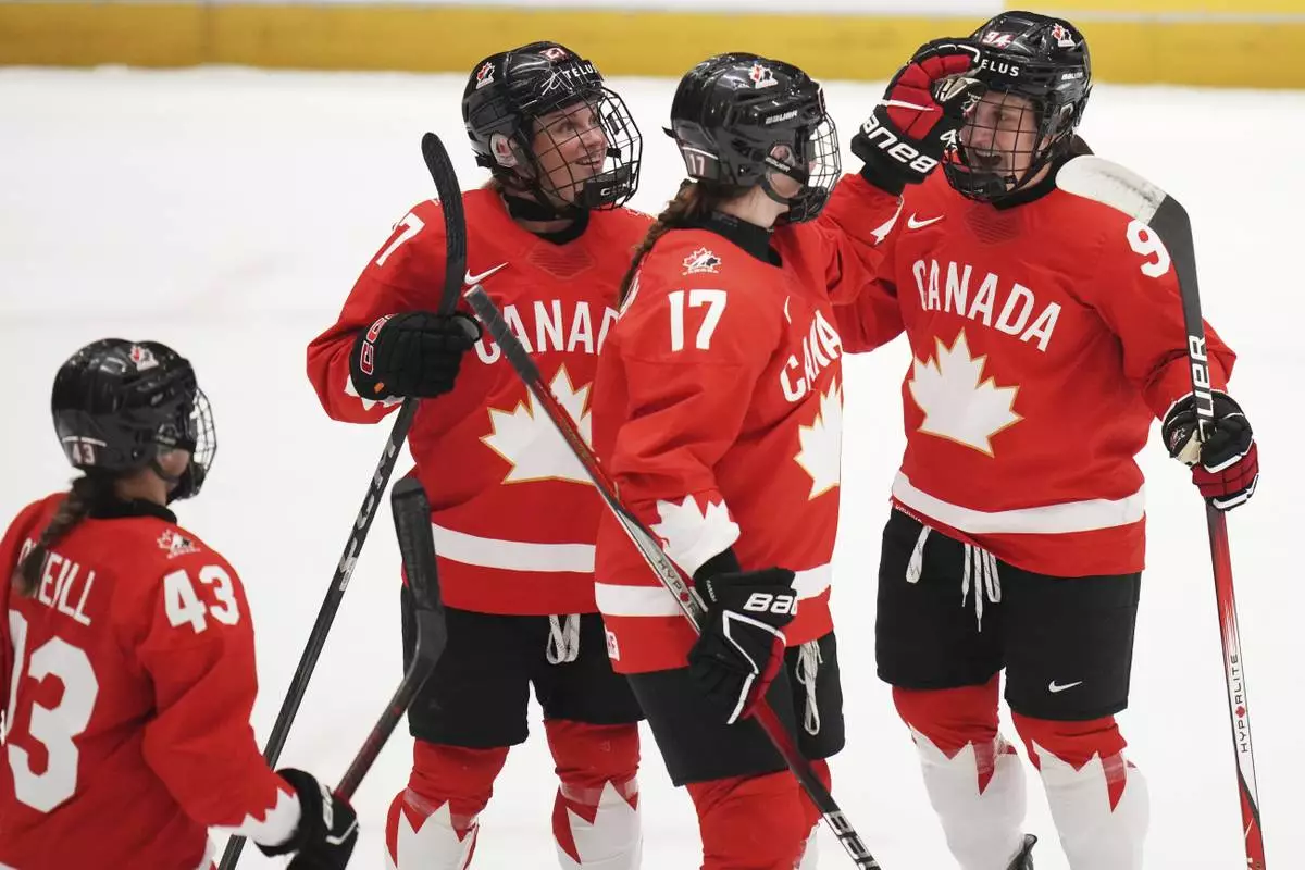 Jennifer Gardiner of Canada, right, celebrates with teammates after scoring her sides second goal during the quarterfinal match between Canada and Japan at the Women's Ice Hockey Championships in Ceske Budejovice, Czech Republic, Thursday, April 17, 2025. (AP Photo/Petr David Josek)