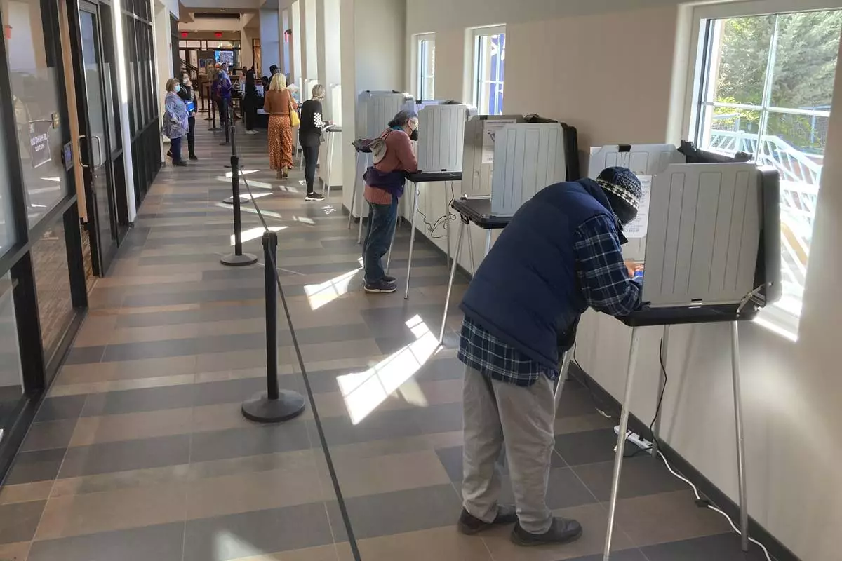 FILE - Santa Fe County, N.M., residents fill out general election ballots during the first day of general election voting, Oct. 11, 2022, in a hallway outside the Santa Fe County Clerk's Office in Santa Fe, N.M. (AP Photo/Morgan Lee, File)