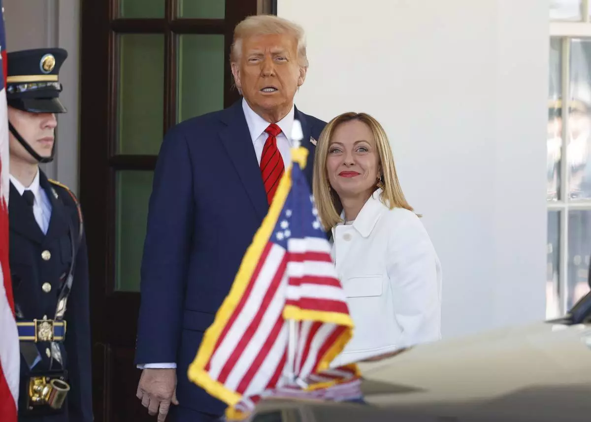 President Donald Trump, center, greets Italy's Prime Minister Giorgia Meloni, right, upon her arrival at the White House, Thursday, April 17, 2025, in Washington. (AP Photo/Tom Brenner)
