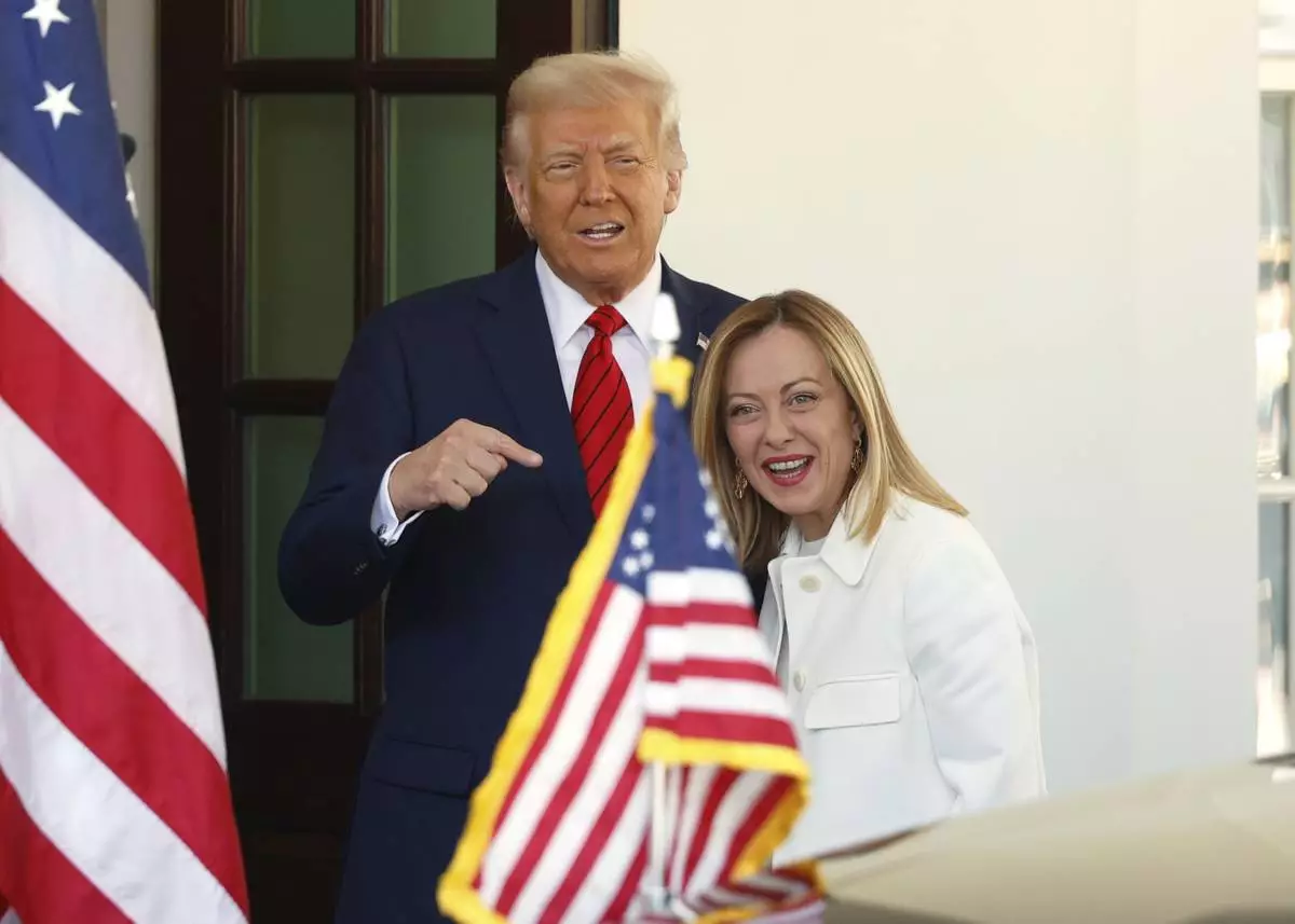 President Donald Trump, left, greets Italy's Prime Minister Giorgia Meloni upon her arrival at the White House, Thursday, April 17, 2025, in Washington. (AP Photo/Tom Brenner)