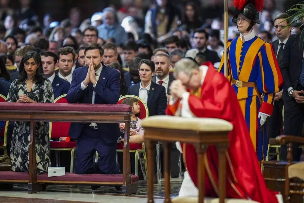 U.S. Vice President JD Vance, and his wife Usha Vance, left, with their daughter Mirabel, attend a Good Friday service led by Cardinal Claudio Gugerotti, right, inside St. Peter's Basilica at the Vatican, Friday, April 18, 2025. (AP Photo/Alessandra Tarantino)