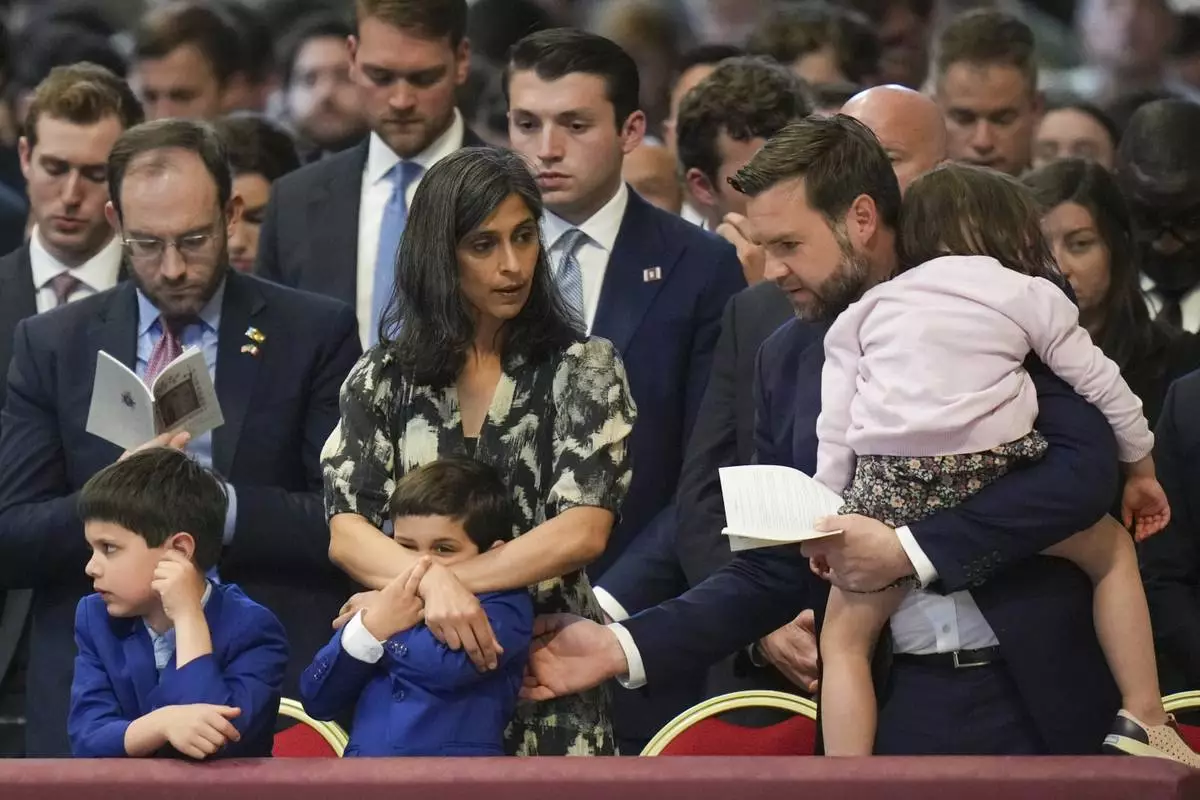 U.S. Vice President JD Vance, and his wife Usha Vance, with their daughter Mirabel, back to camera, and sons Vivek and Ewan, left, attend a Good Friday service inside St. Peter's Basilica at the Vatican, Friday, April 18, 2025. (AP Photo/Alessandra Tarantino)