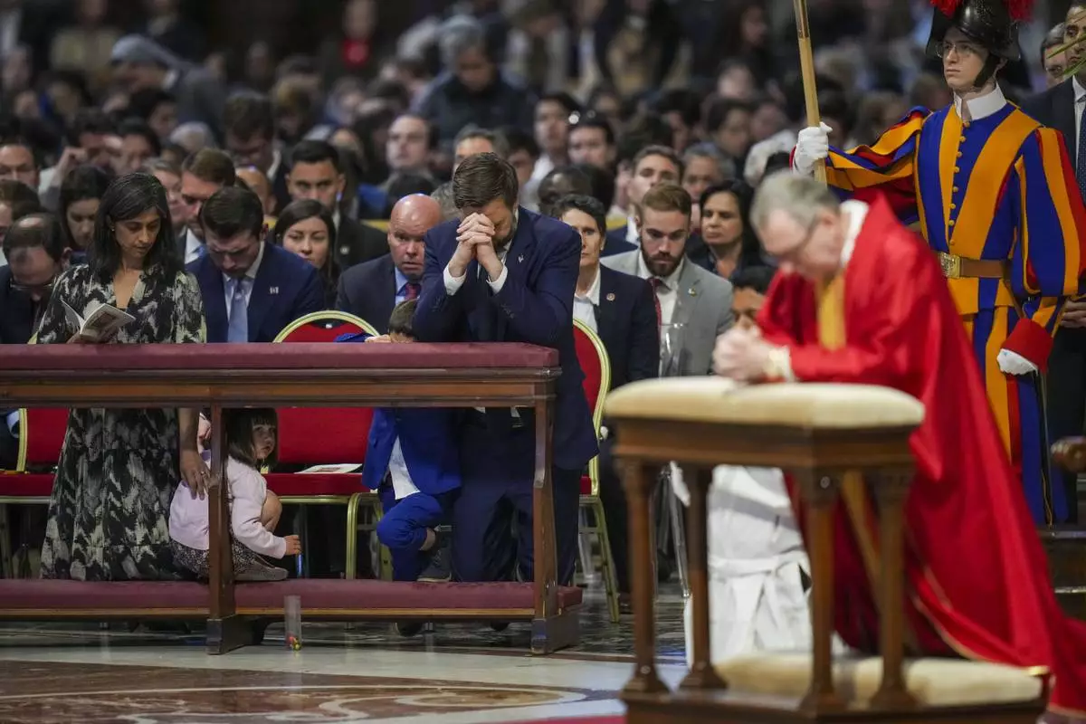 U.S. Vice President JD Vance, and his wife Usha Vance, left, with their daughter Mirabel attend a Good Friday service led by Cardinal Claudio Gugerotti, right, inside St. Peter's Basilica at the Vatican, Friday, April 18, 2025. (AP Photo/Alessandra Tarantino)