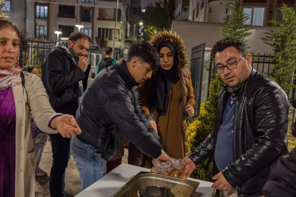 Locals collect food in a distribution point as they camp outdoors following an earthquake in Istanbul, Turkey, Wednesday, April 23, 2025. (Omer Yildiz/Dia Photo via AP)