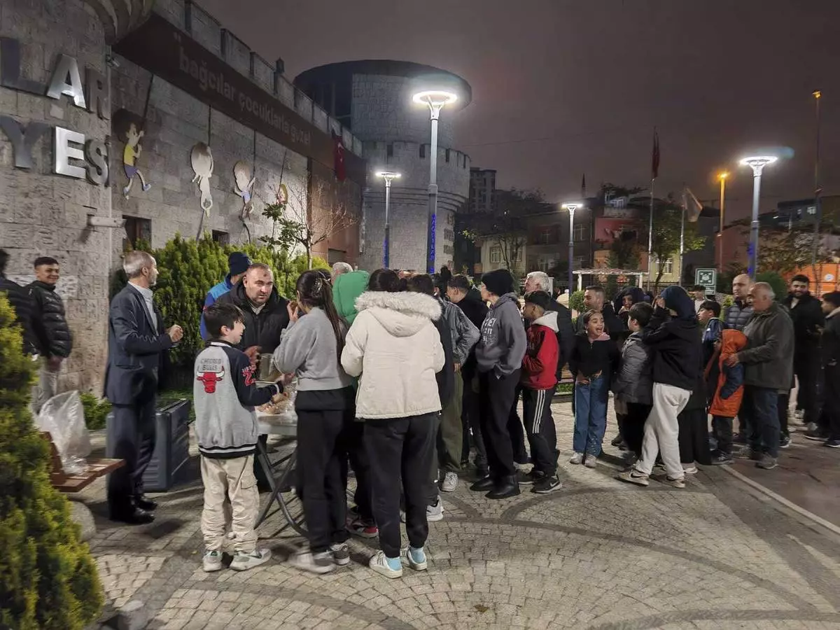 Locals collect food in a distribution point as they camp outdoors following an earthquake in Istanbul, Turkey, Wednesday, April 23, 2025. (Omer Yildiz/Dia Photo via AP)