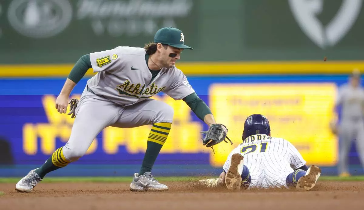 Milwaukee Brewers' Caleb Durbin (21) steals second base as the Athletics' Jacob Wilson applies the late tag during the fourth inning of a baseball game, Sunday, April 20, 2025, in Milwaukee. (AP Photo/Jeffrey Phelps)
