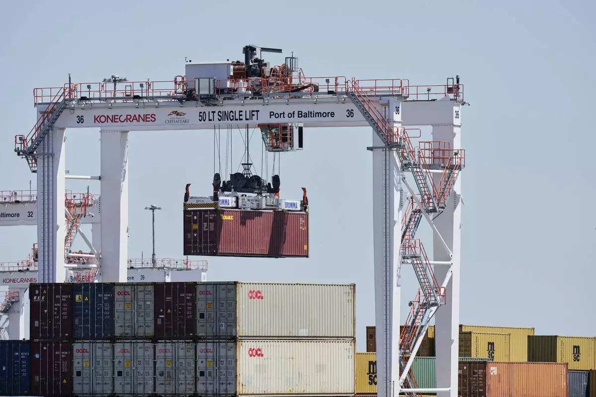 A crane lifts a container at the Port of Baltimore, Wednesday, April 9, 2025, in Baltimore. (AP Photo/Stephanie Scarbrough)