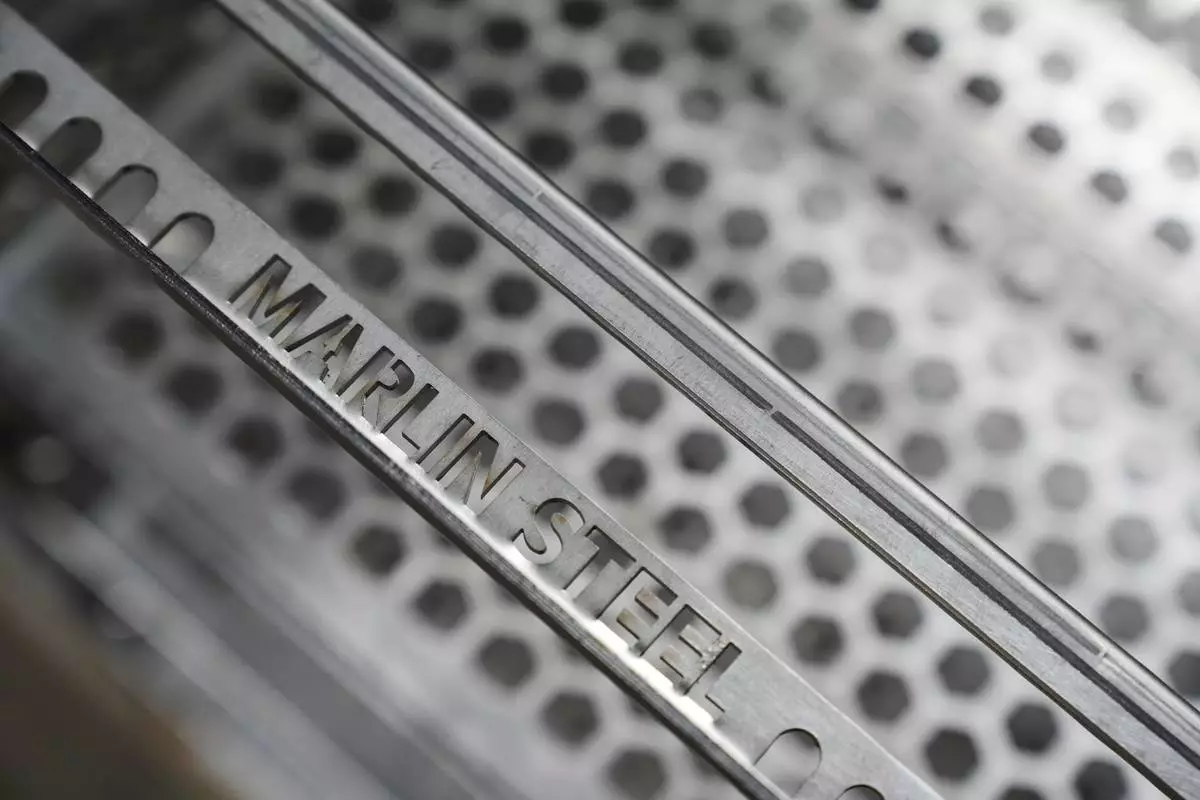 Name-plated steel pieces are seen at the Marlin Steel Wire manufacturing plant in Baltimore, Thursday, April 17, 2025. (AP Photo/Stephanie Scarbrough)