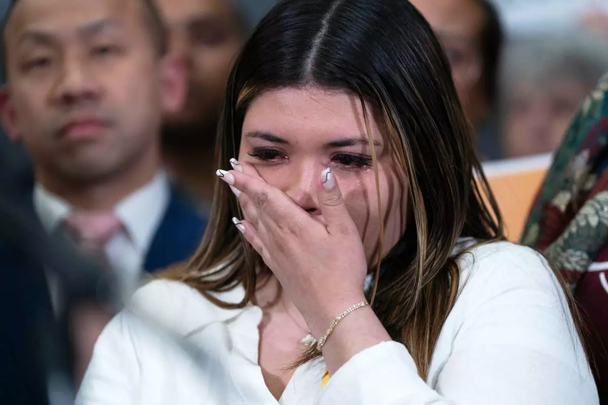 Jennifer Vasquez Sura wipes a tear from her face as Sen. Chris Van Hollen, D-Md., speaks during a news conference upon his arrival from meeting with her husband, Kilmar Abrego Garcia, in El Salvador, at Washington Dulles International Airport, in Chantilly, Va., Friday, April 18, 2025. (AP Photo/Jose Luis Magana)