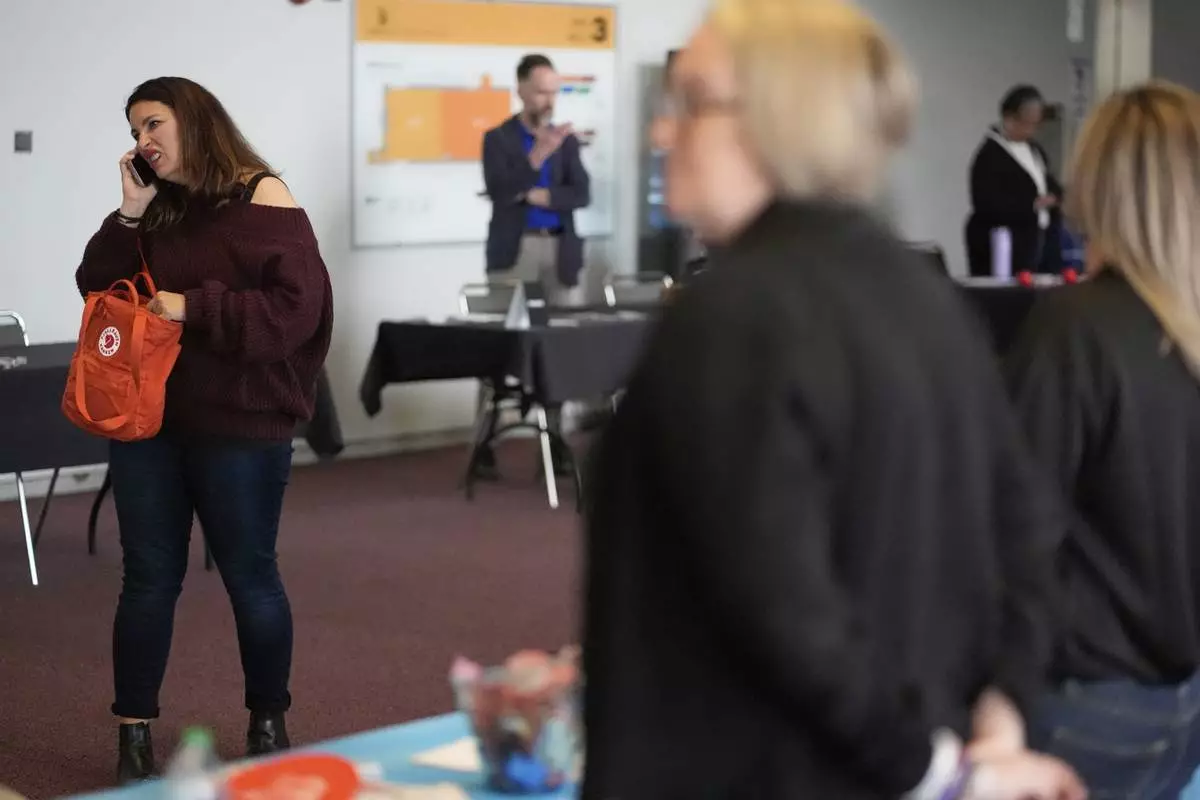 Shea Giagnorio, left, takes a phone call while at a job fair on the day she was laid off from her job at the Administration for Children and Families, Tuesday, April 1, 2025, in Kansas City, Mo. (AP Photo/Charlie Riedel)