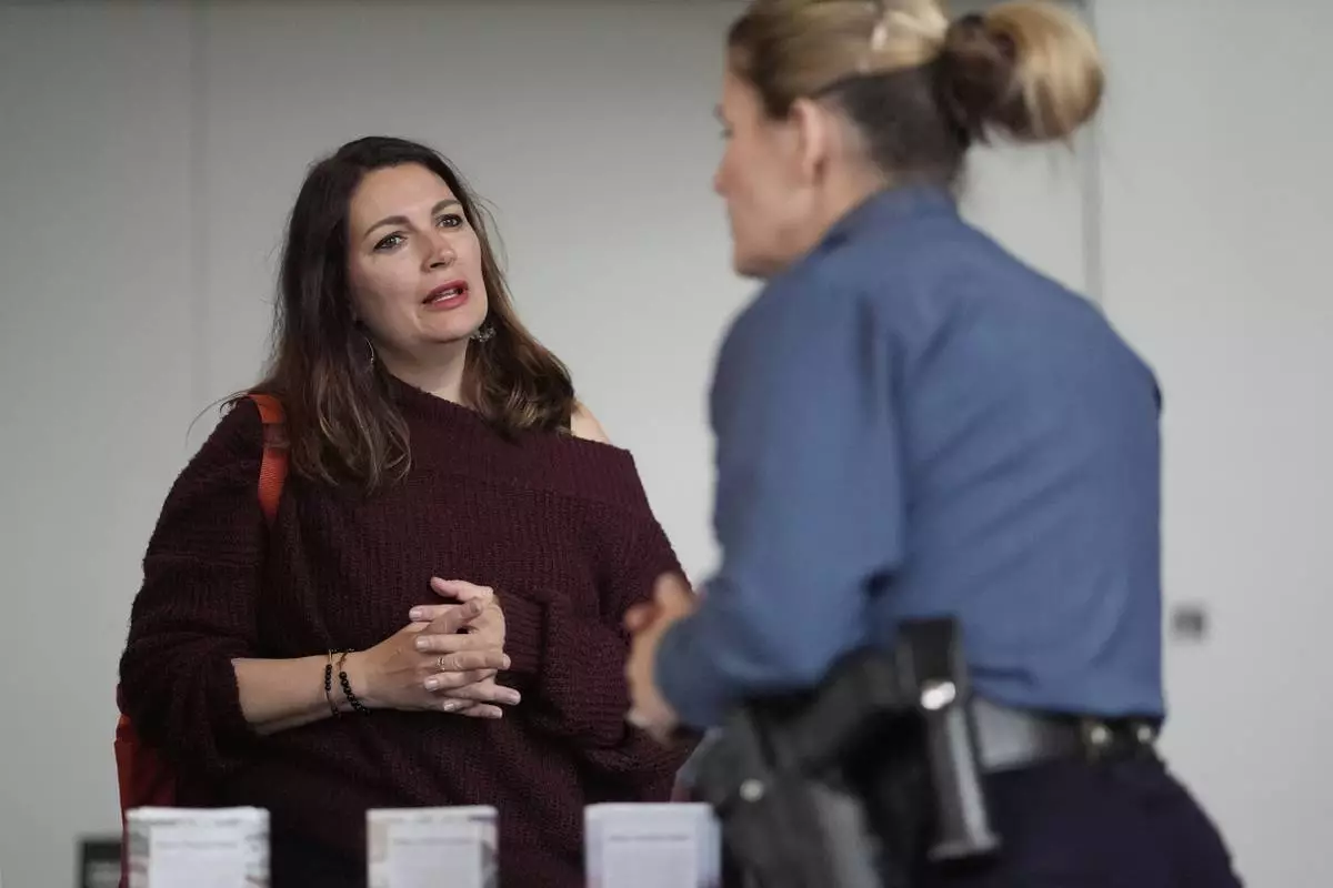 Shea Giagnorio, left, talks to a recruiter at a job fair on the day she was laid off from her job at the Administration for Children and Families, Tuesday, April 1, 2025, in Kansas City, Mo. (AP Photo/Charlie Riedel)