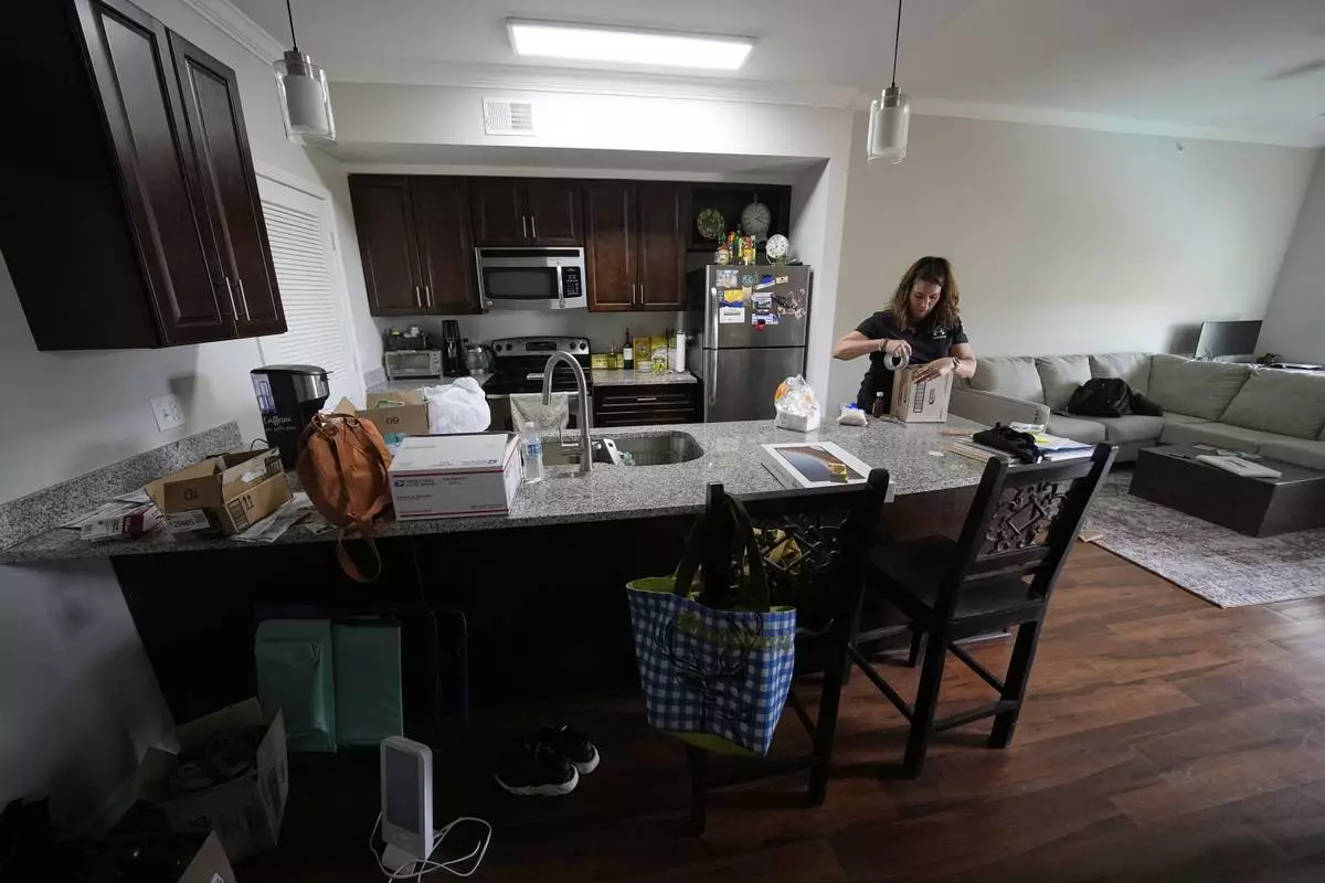 Shea Giagnorio packs belongings in her apartment days after getting fired from her job with the Administration for Children and Families, Monday, April 14, 2025, in Overland Park, Kan. (AP Photo/Charlie Riedel)