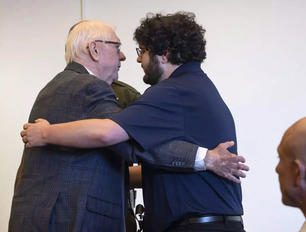Orange County Superior Judge Jeffrey Ferguson, left, who was found guilty of second-degree murder in the shooting death of his wife Sheryl Ferguson in 2023, embraces his son, Phillip Ferguson, before being led away in handcuffs on Tuesday, April 22, 2025, in Santa Ana, Calif. (Mindy Schauer/The Orange County Register via AP, Pool)